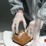 Profissional usando equipamento de proteção analisa uma substância em pó em um laboratório