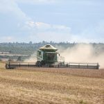 Colheitadeira trabalhando em uma extensa plantação de soja no Brasil.