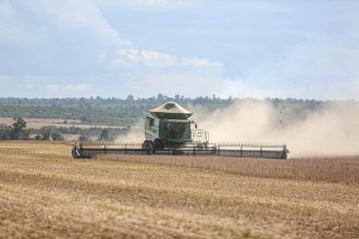Colheitadeira trabalhando em uma extensa plantação de soja no Brasil.