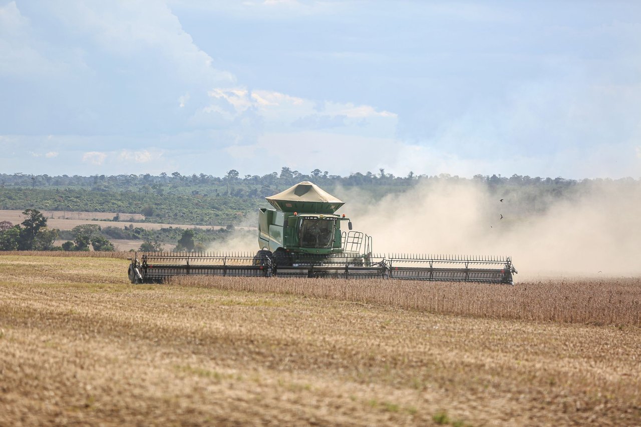 Colheitadeira trabalhando em uma extensa plantação de soja no Brasil.