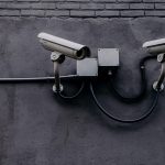 Câmera de vigilância instalada em uma parede, usada para monitoramento e segurança.