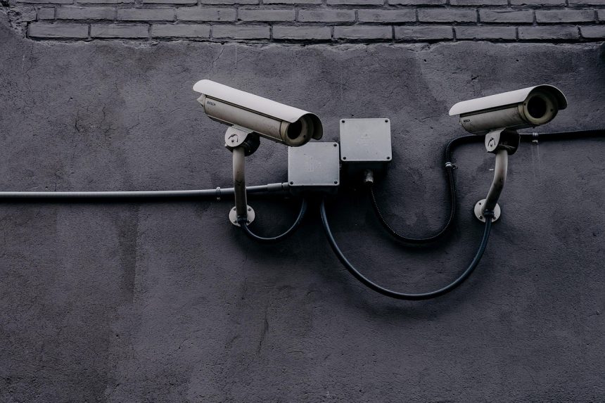 Câmera de vigilância instalada em uma parede, usada para monitoramento e segurança.