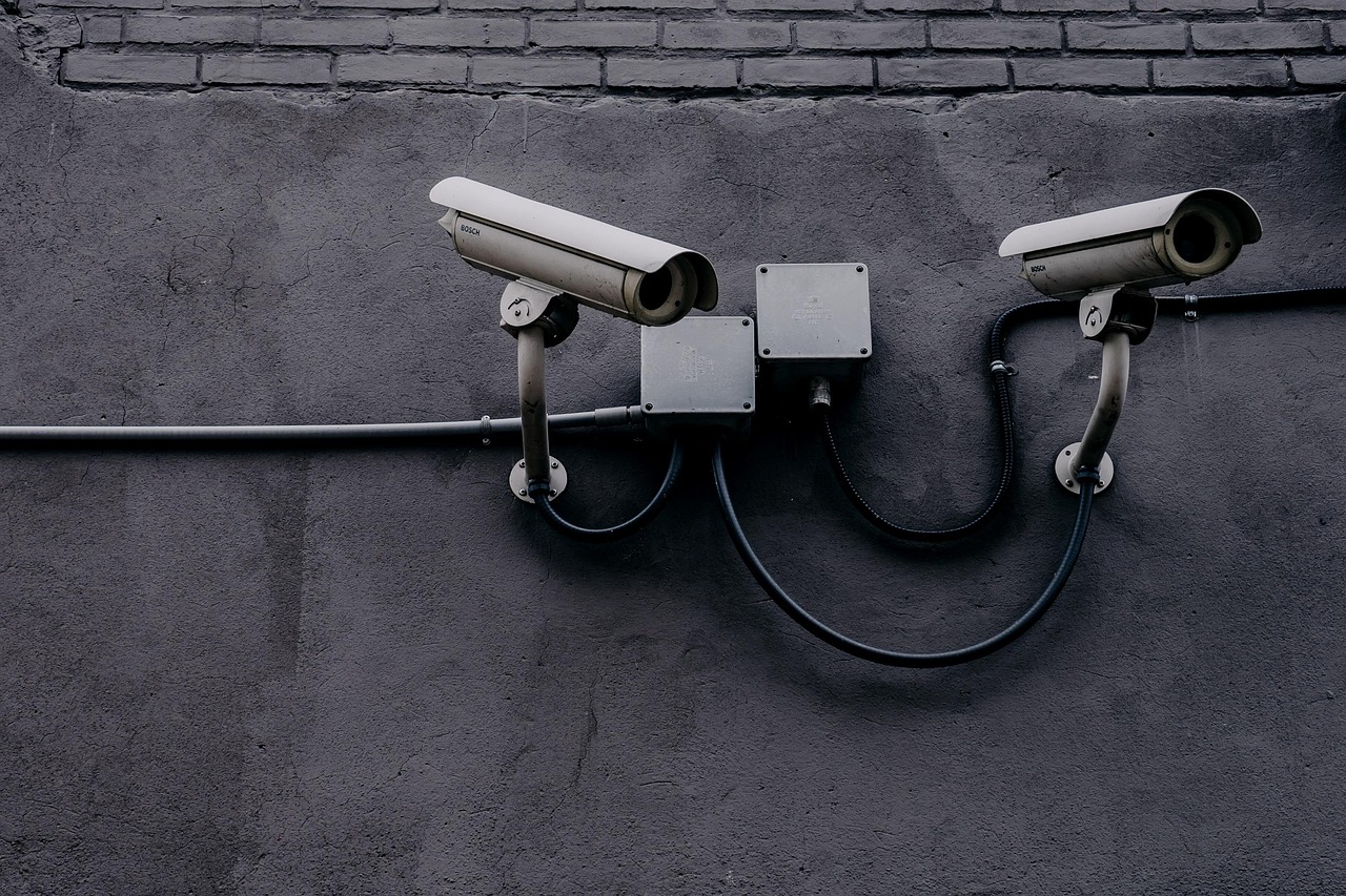 Câmera de vigilância instalada em uma parede, usada para monitoramento e segurança.