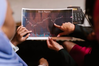 Profissionais analisam um gráfico de dados econômicos durante uma reunião.